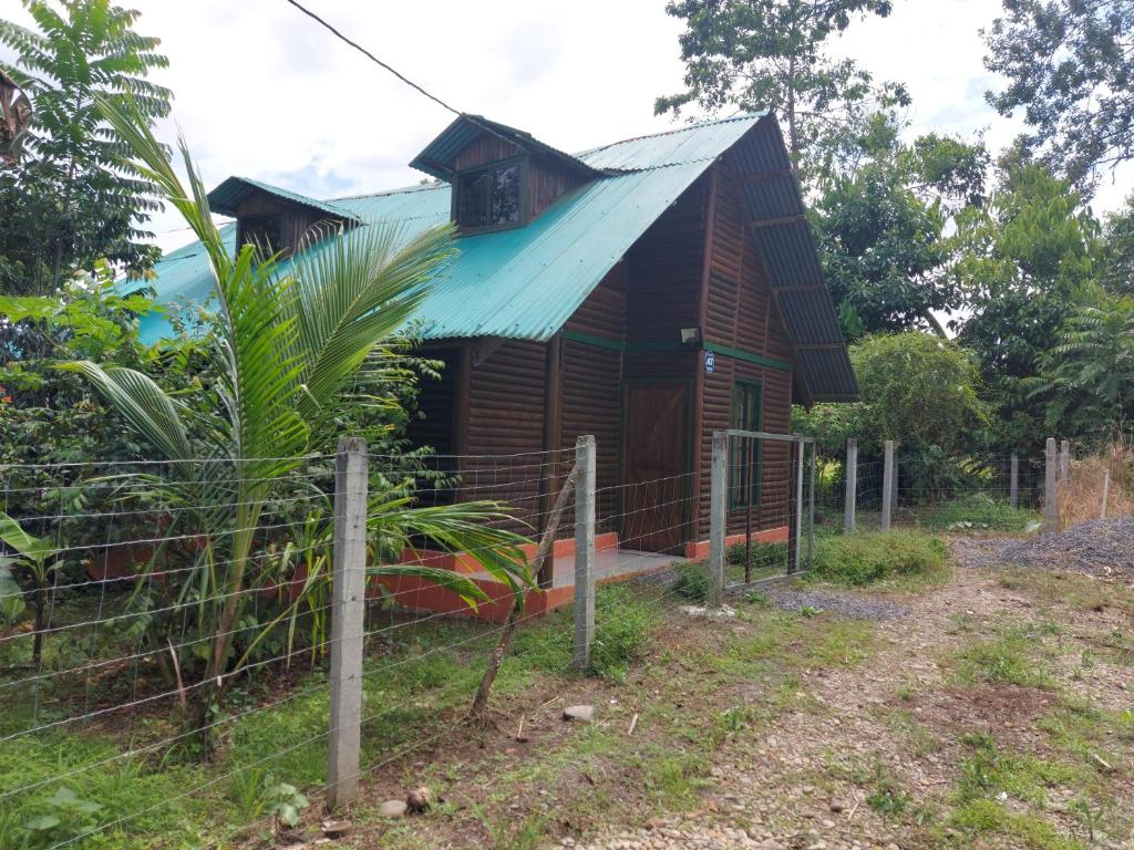 una pequeña casa de madera con techo de metal en Cabaña para vacacionar río Sarapiqui, en Sarapiquí