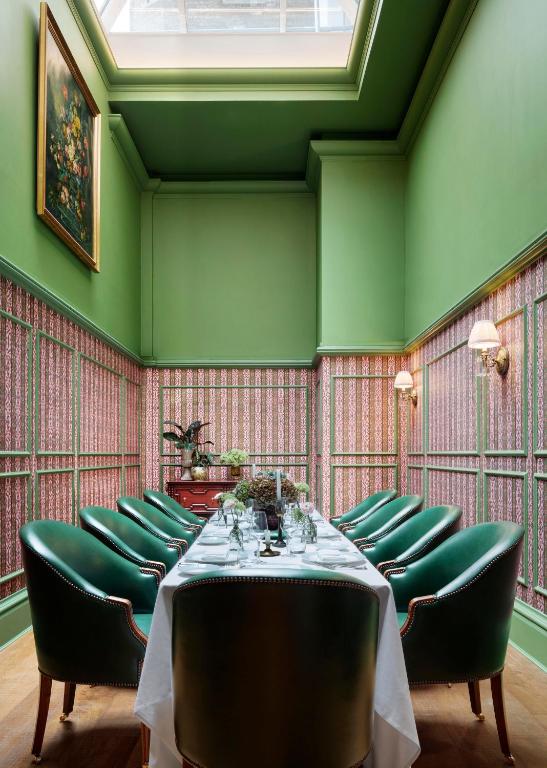 a dining room with green walls and a table with green chairs at The Randolph Hotel Oxford, a Graduate by Hilton Hotel in Oxford