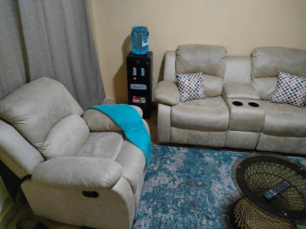 een woonkamer met 2 stoelen en een bank bij Alken Homes - One Bedroom, Naivasha in Naivasha