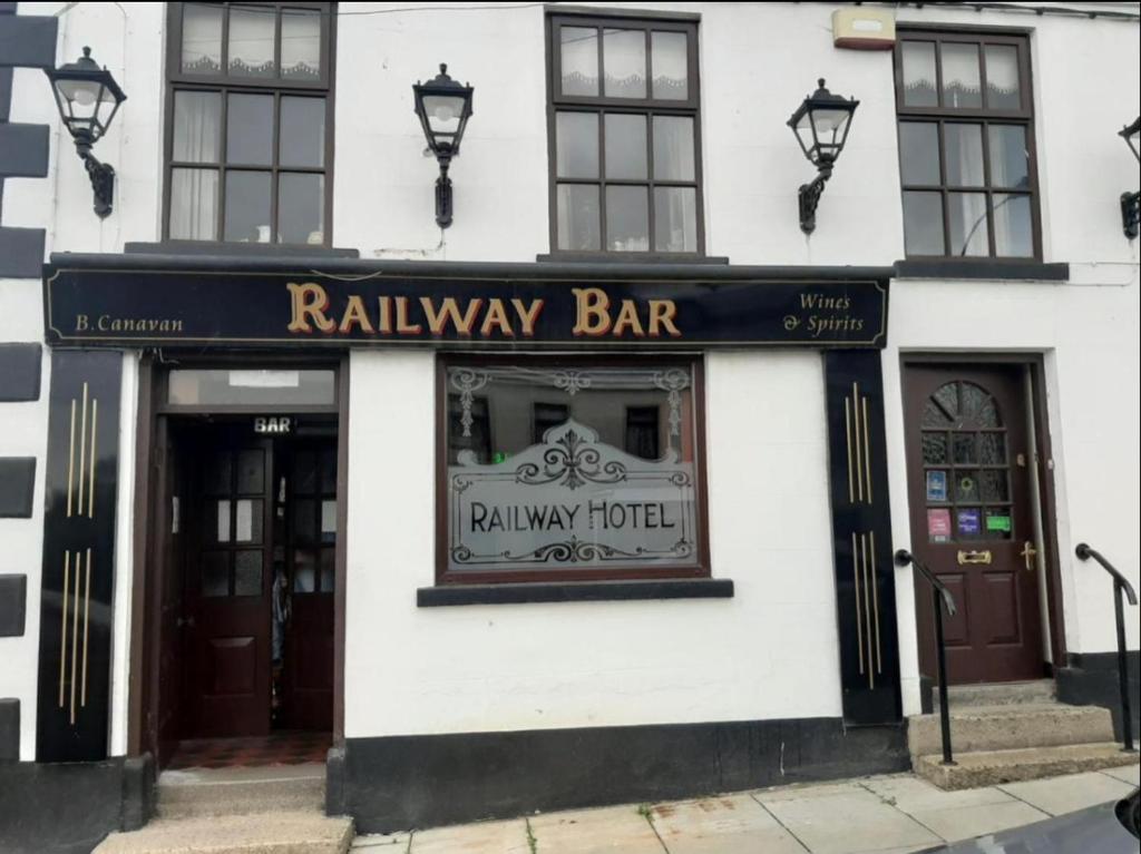 a white building with a railway bar sign on it at Railway Bar Apartment in Poyntz Pass