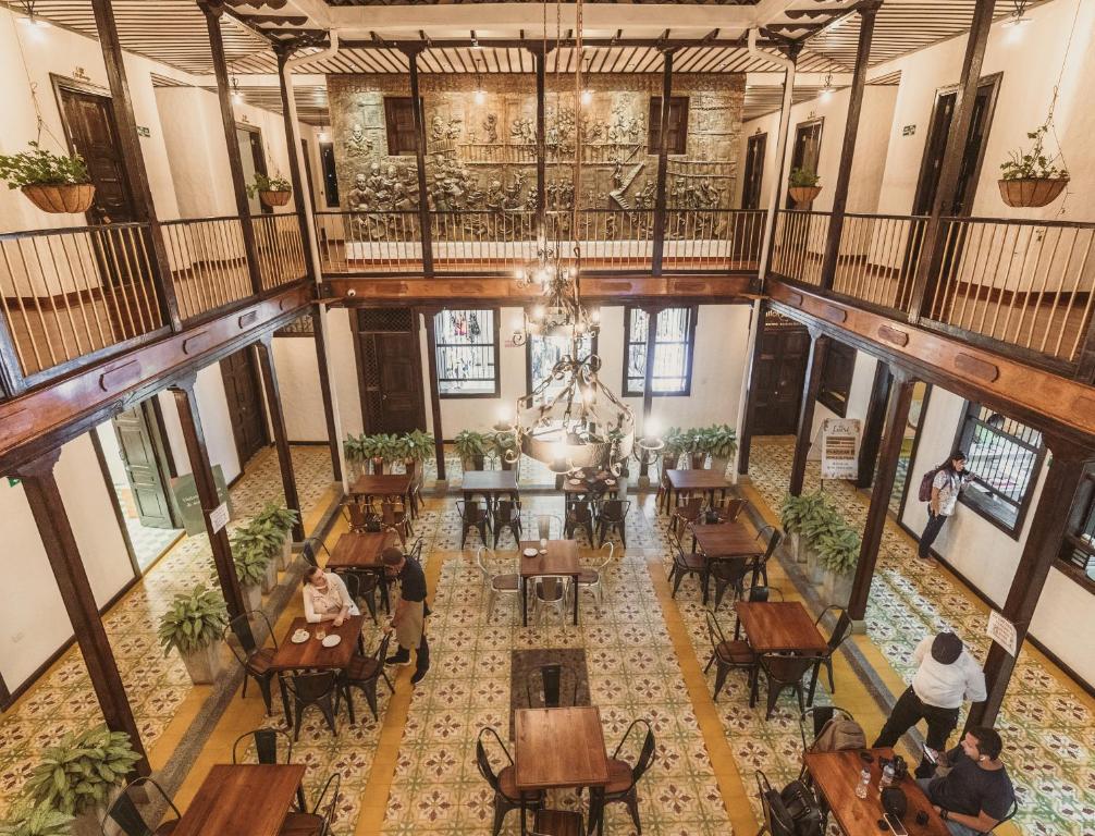 eine Aussicht über die Lobby eines Gebäudes mit Tischen in der Unterkunft Hotel Boutique La Leyenda 1860 in Salamina