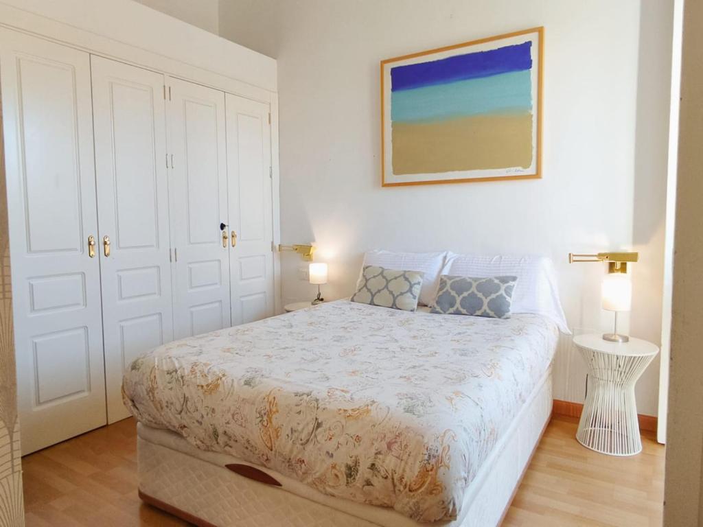 1 dormitorio con 1 cama y una foto en la pared en Lovely apartment in Seville city center, Parking Optional, en Sevilla