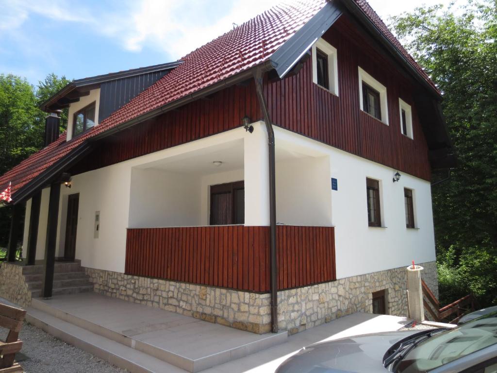 a house with a red and white facade at Guest House Wolf in Jezerce