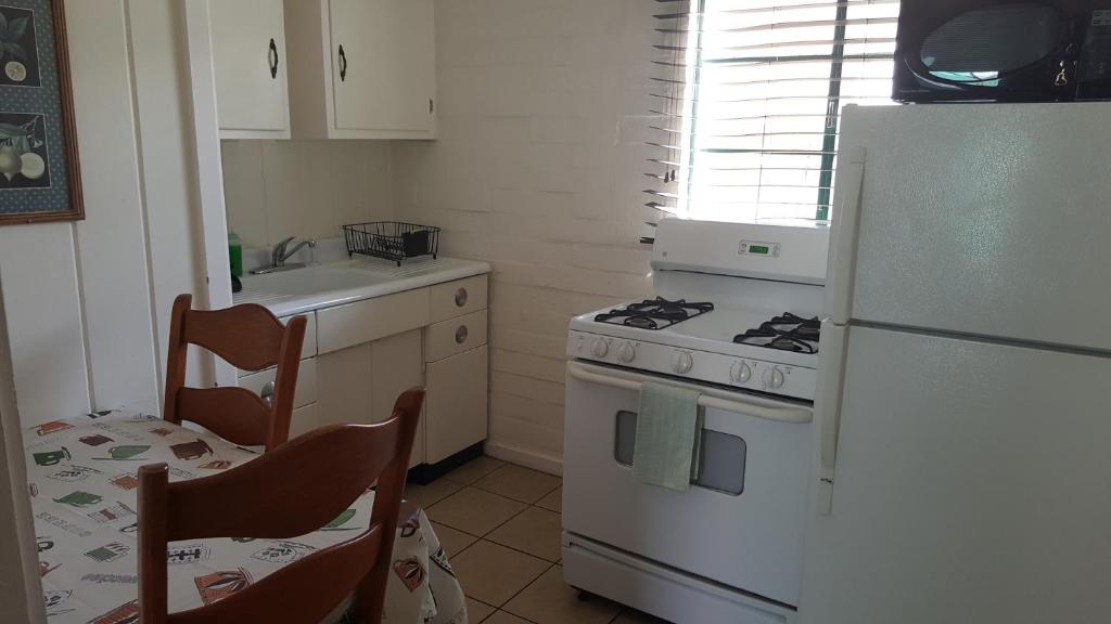 a kitchen with a white stove and a refrigerator at Bishop Village Motel in Bishop