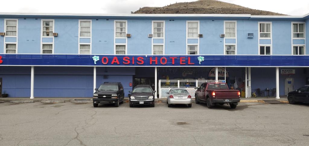 um hotel azul com carros estacionados em frente em Oasis Hotel em Cache Creek