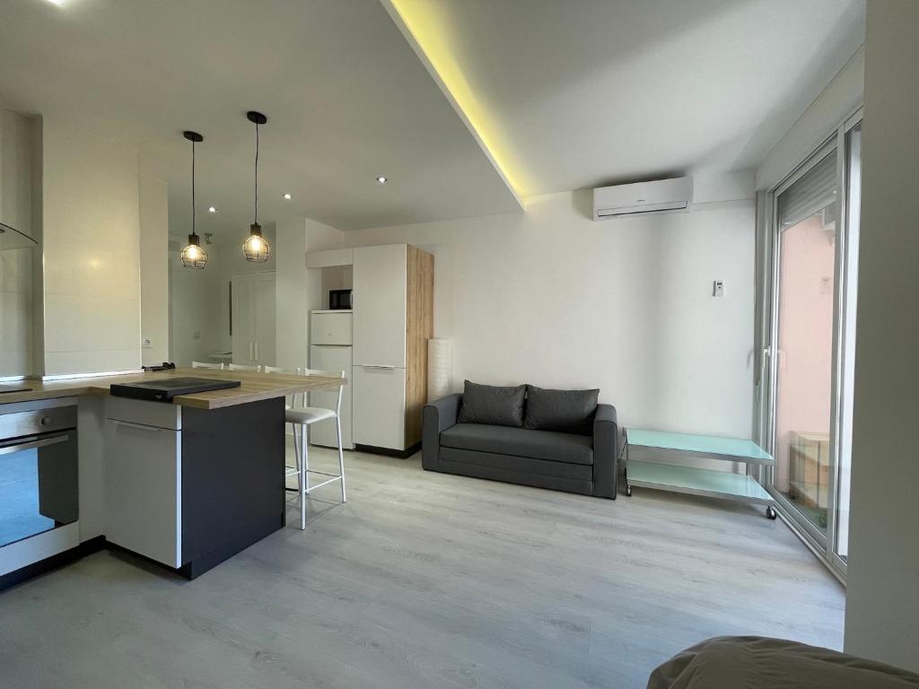 a kitchen and living room with a couch and a table at Acogedor y novedoso Loft en Torrevieja in Torrevieja