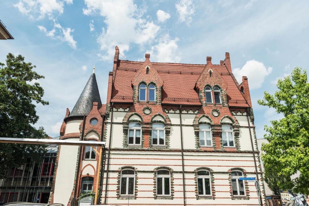 ein altes Gebäude mit rotem Dach in der Unterkunft Apartmenthaus am Dom mit Parkplatz in Zwickau