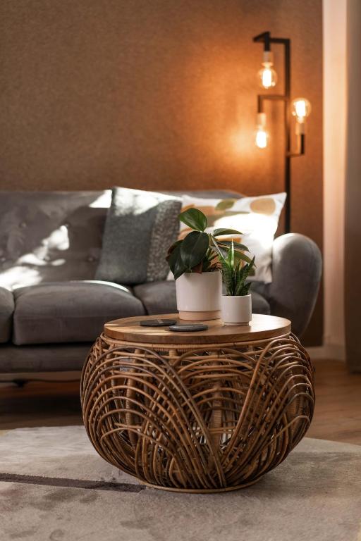 a wicker coffee table in a living room with a couch at Villa Eltins in Bad Bentheim