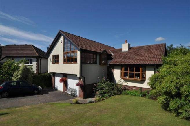 una casa con un coche aparcado delante de ella en Kilburn Holiday Cottage, en Largs