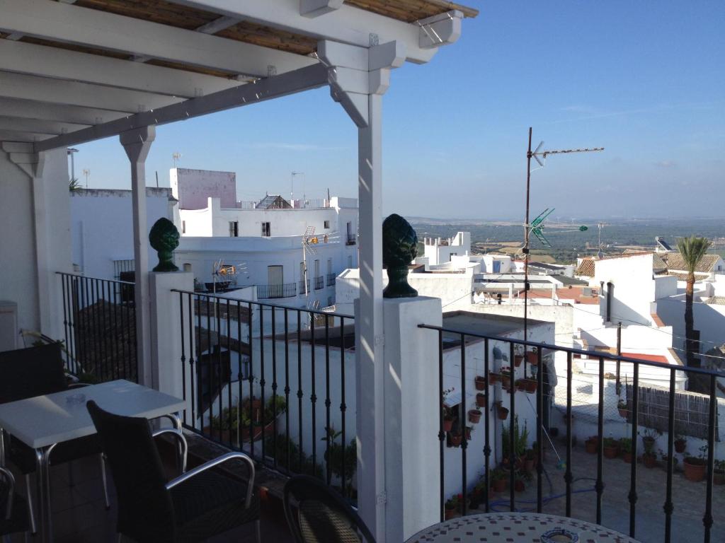 uma varanda com mesas e cadeiras e vista para a cidade em Apartamentos Casa la Costanilla em Vejer de la Frontera
