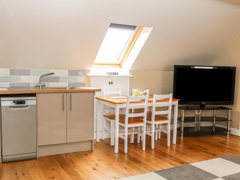 a kitchen with a table with chairs and a tv at Providence Apartment in Epworth