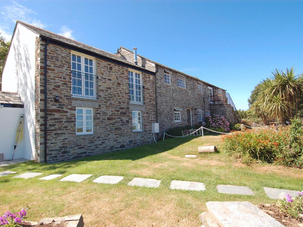 a brick building with a yard in front of it at Atlantic View in Tintagel