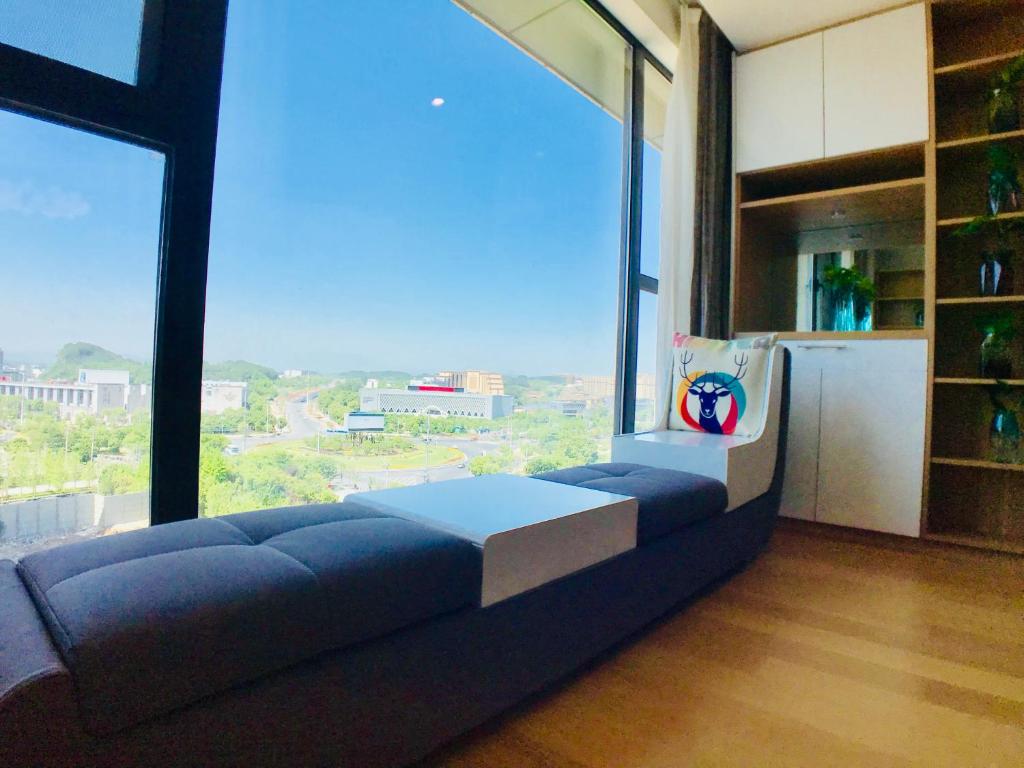 un soggiorno con un divano e una grande finestra di Huangshan Sky Small Nest B&B a Huangshan