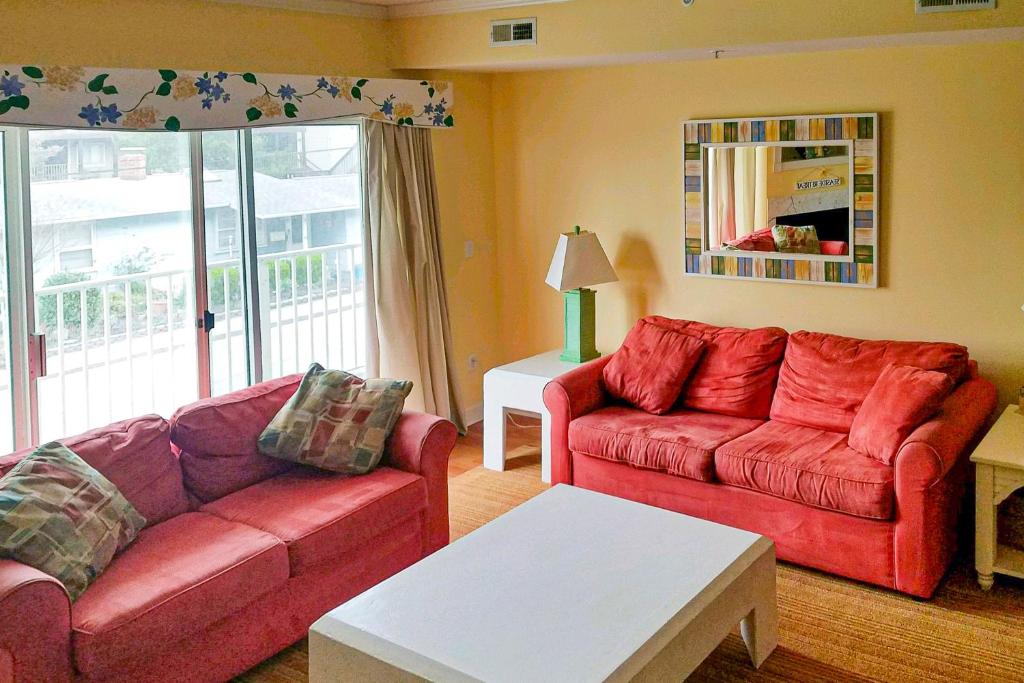 a living room with two red couches and a table at Island Cabana in Ocean City