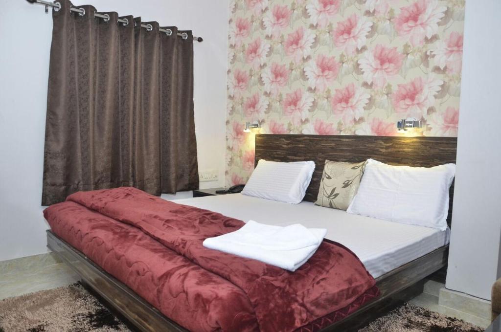 a bedroom with a bed with a red blanket at Hotel Kanha Inn in Lucknow