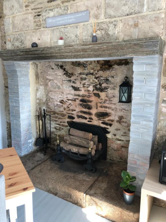 a stone wall with a fire place and a stone fireplace at Maison De Vacances A Brambuan in Josselin