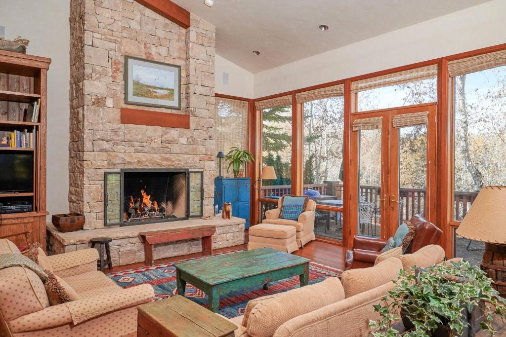 a living room with a fireplace and a stone wall at Aspen Meadows Resort 111 in Aspen