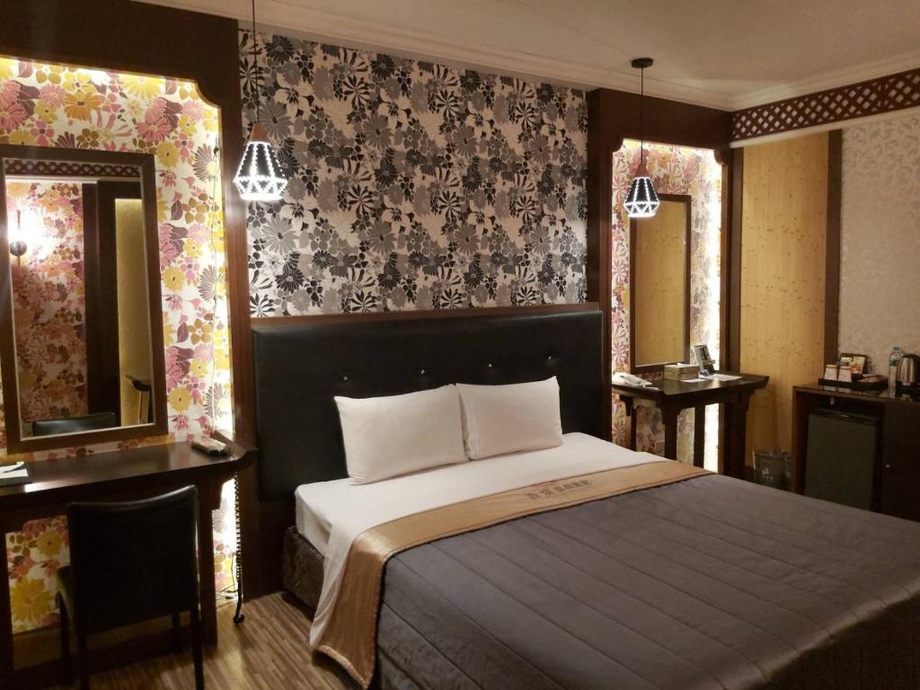 a bedroom with a large bed and two mirrors at CHATEAU MOTEL (Crystal Code Museum) in Kaohsiung