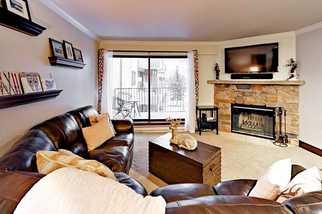 a living room with leather furniture and a fireplace at Beaver Creek West G3 in Beaver Creek
