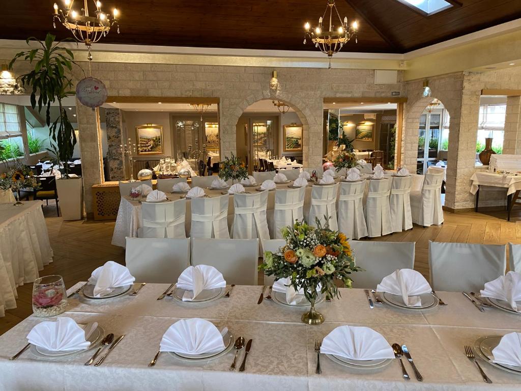 a banquet hall with white tables and white chairs at B&B Ave Maria in Vrpolje