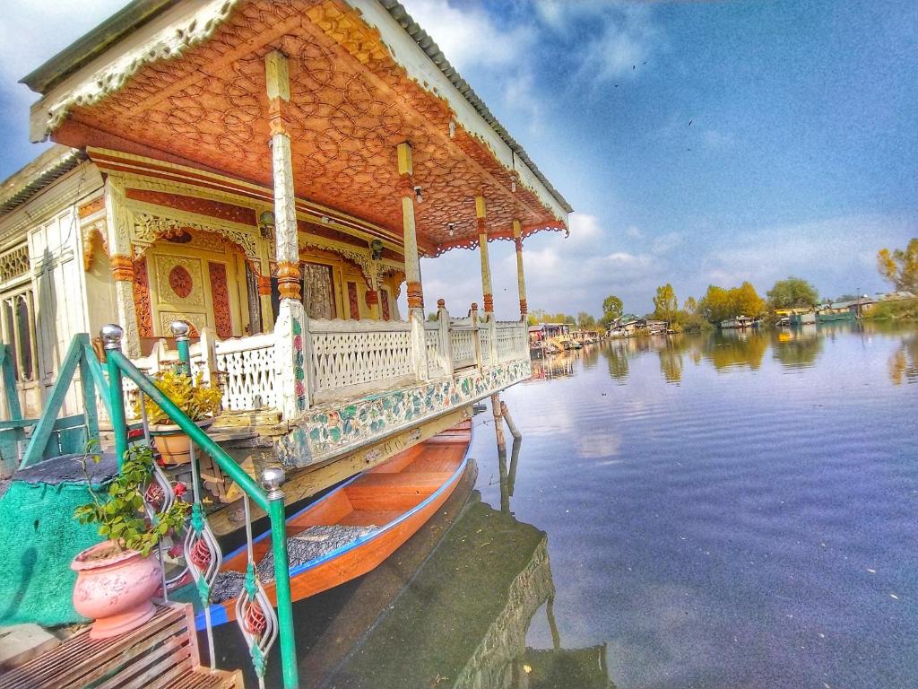 a house on a river with a boat on the water at Houseboat Raja's Palace in Srinagar