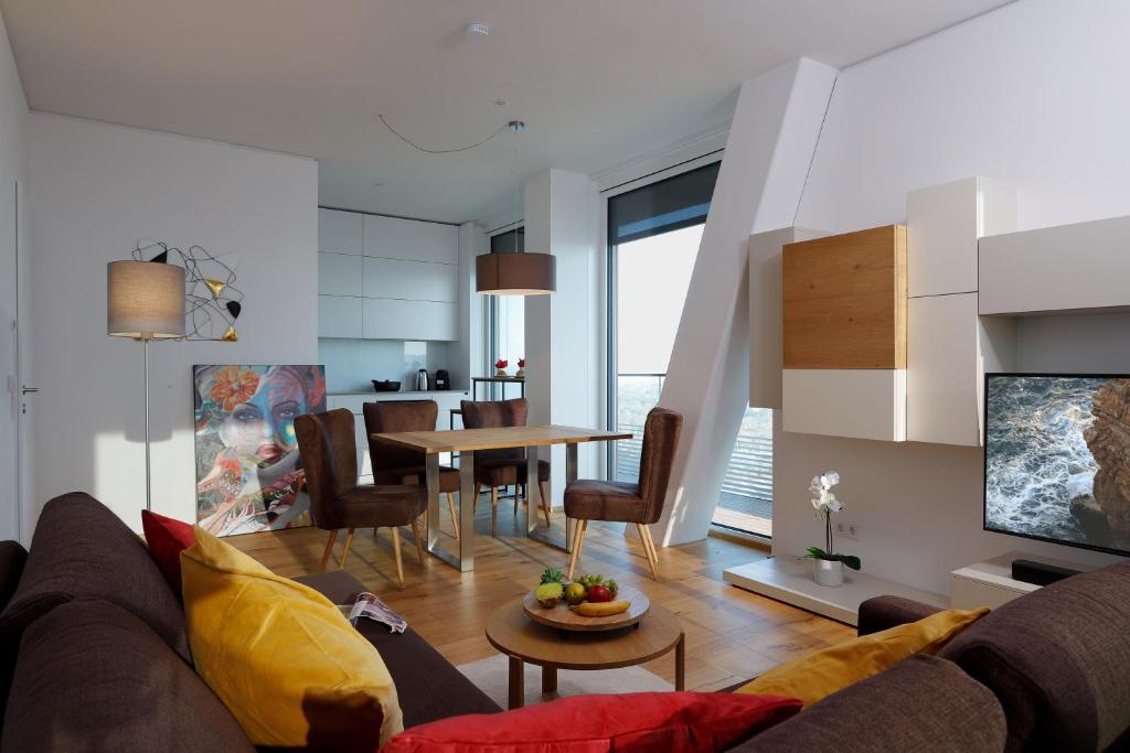 ein Wohnzimmer mit einem Sofa und einem Tisch in der Unterkunft Triiiple Suites Level 21 mit Balkon und Tiefgarage in Wien