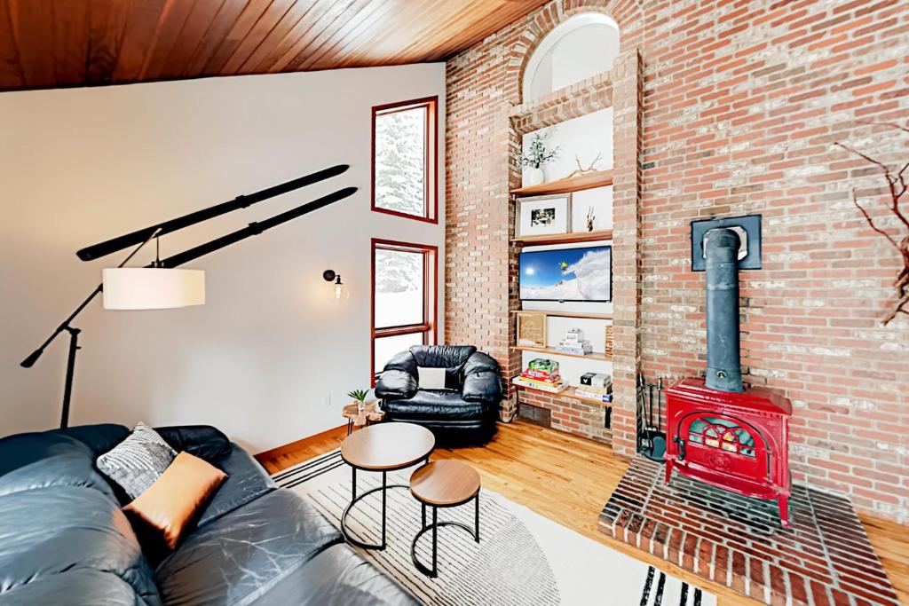 a living room with a brick wall and a fireplace at The GingerBreck House in Breckenridge