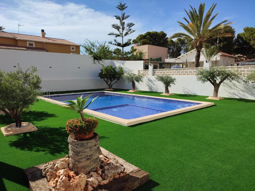 une cour avec une piscine et de l'herbe verte dans l'établissement El Titi, close to the beach, à El Campello