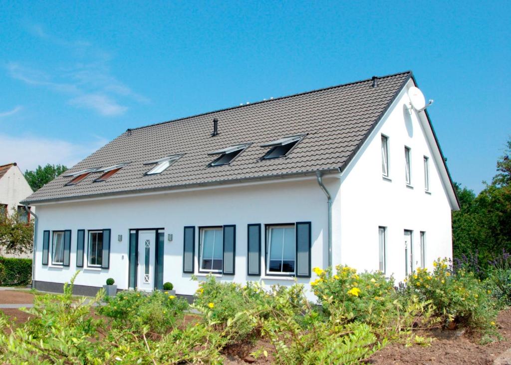 uma casa branca com um telhado preto em LANDHAUS AM SUND im OG em Heiligenhafen