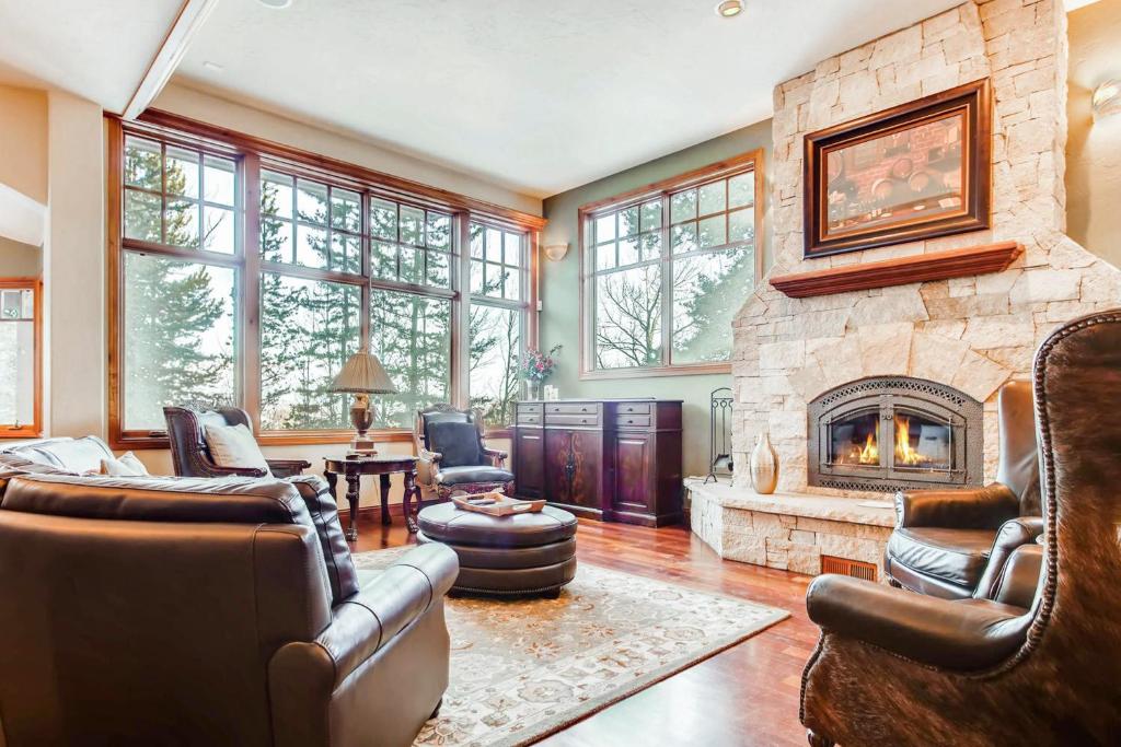 ein Wohnzimmer mit einem großen Steinkamin in der Unterkunft Moose Whiskers in Keystone