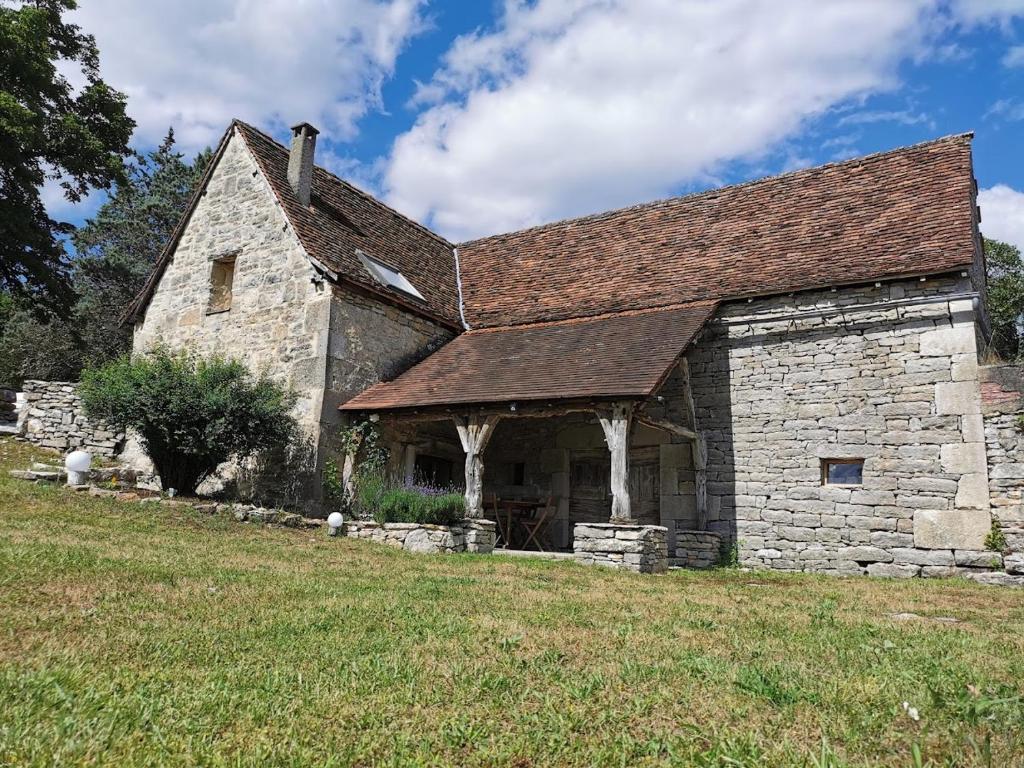 un antiguo edificio de piedra con techo en un campo en THE BARN, MAISON, PISCINE PRIVATIVE, CALME, WIFI en Carayac