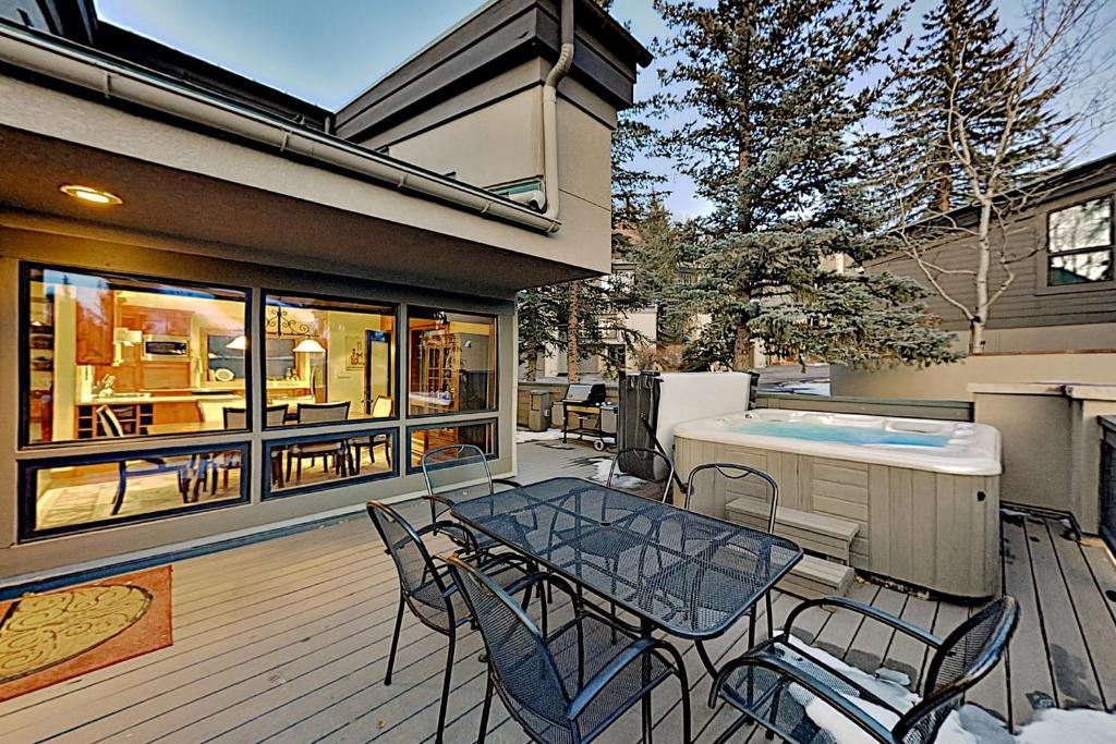 a patio with a table and chairs and a hot tub at Red Sandstone Condo Unit 26 in Vail