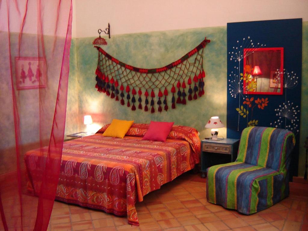 sypialnia z łóżkiem z czerwonym kocem i krzesłem w obiekcie Agriturismo La Dolce Vita Lipari w mieście Lipari