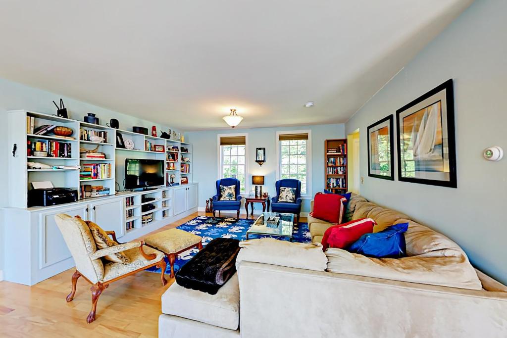 a living room with a couch and chairs and a tv at East Boothbay Gardens in East Boothbay
