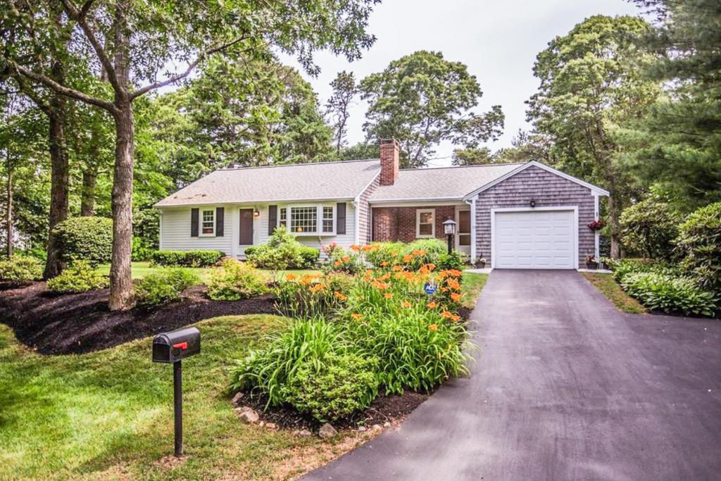 a house with a white garage and a driveway at Collingwood Cottage in Yarmouth Port