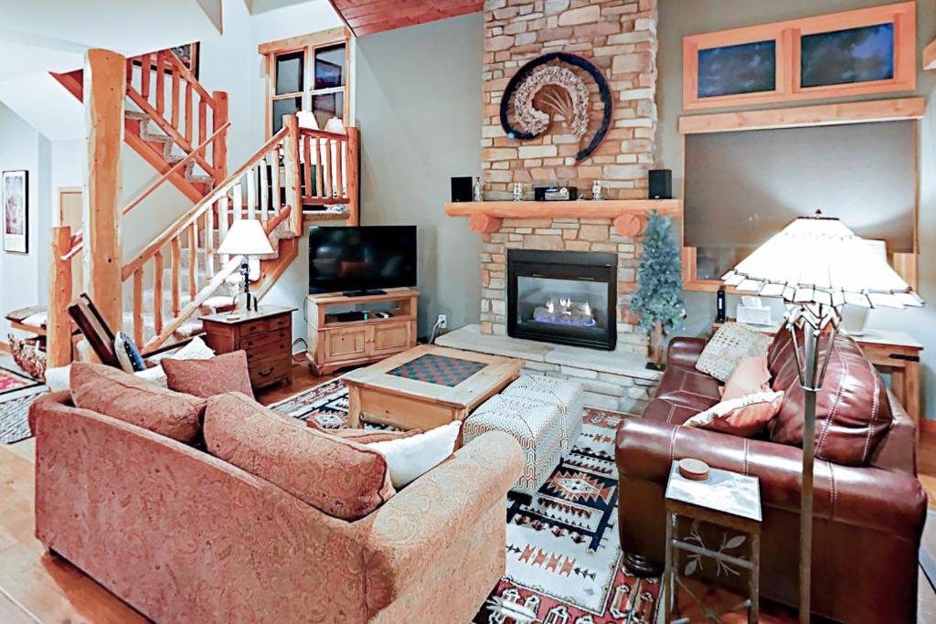 uma sala de estar com dois sofás e uma lareira em Northstar Townhome Unit 1968 em Keystone