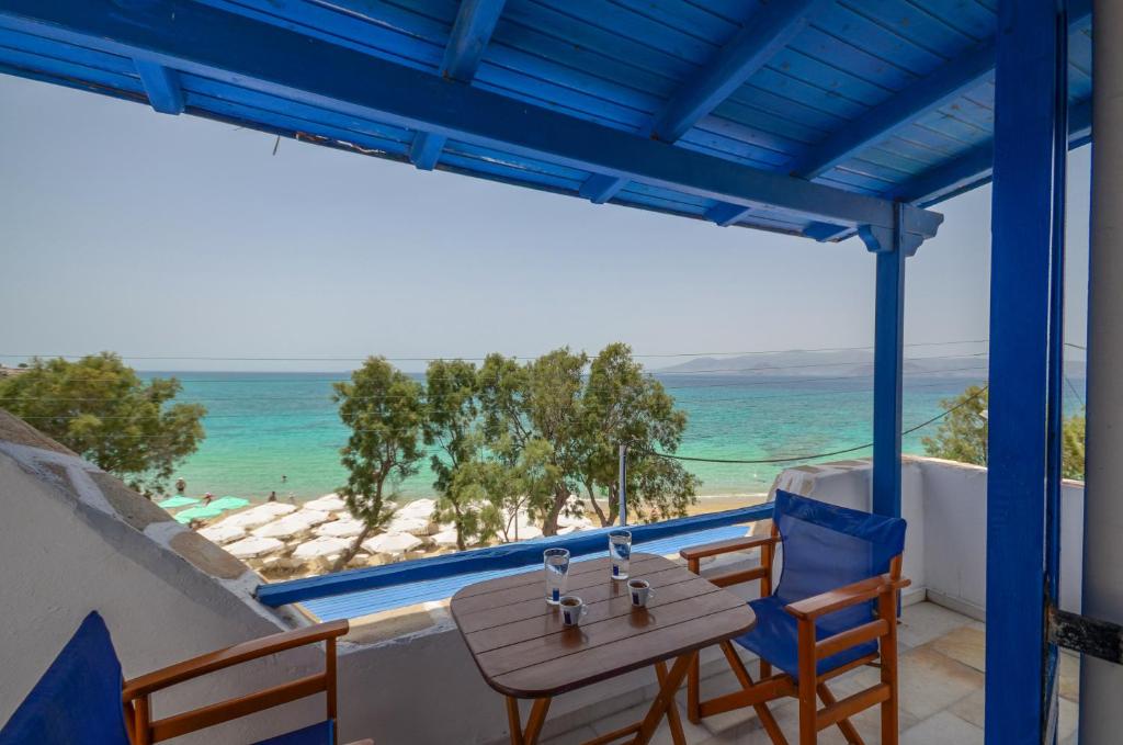 una mesa y sillas en un balcón con vistas al océano en Naxos Golden Beach 2, en Agia Anna de Naxos