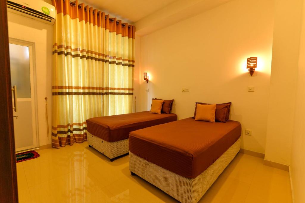 a bedroom with two beds and a window at 2B1 weligama in Weligama