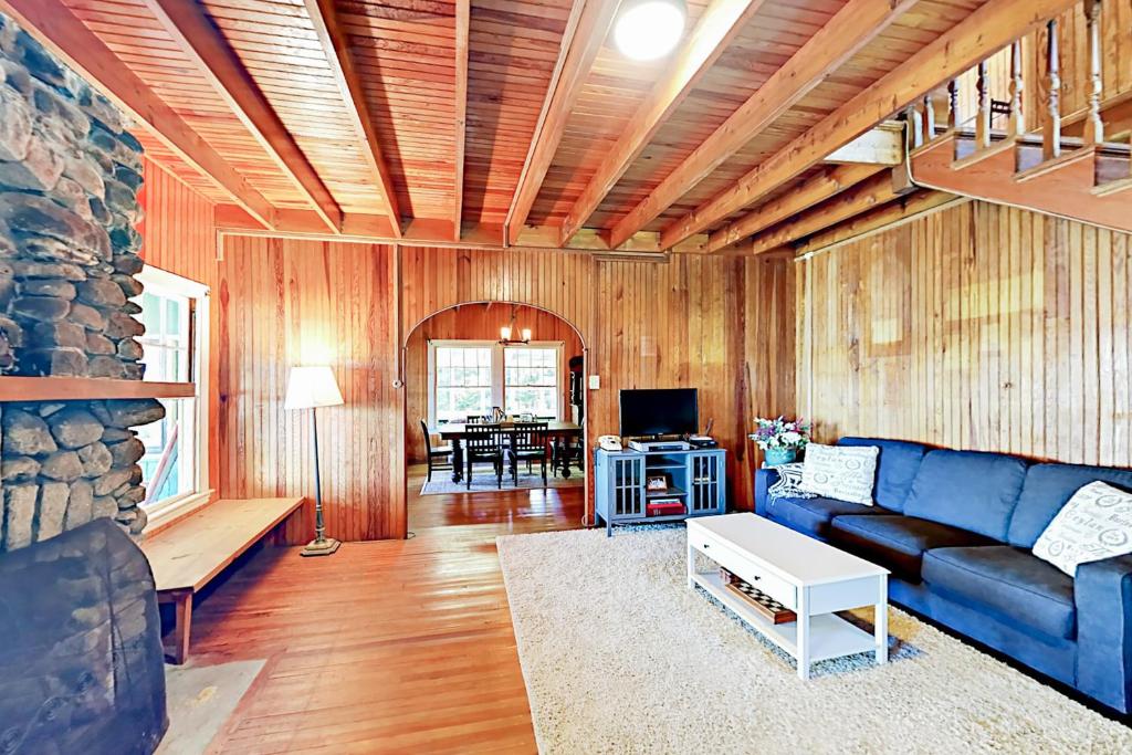 ein Wohnzimmer mit einem blauen Sofa und einem Tisch in der Unterkunft Green Gables Cottage in Friendship