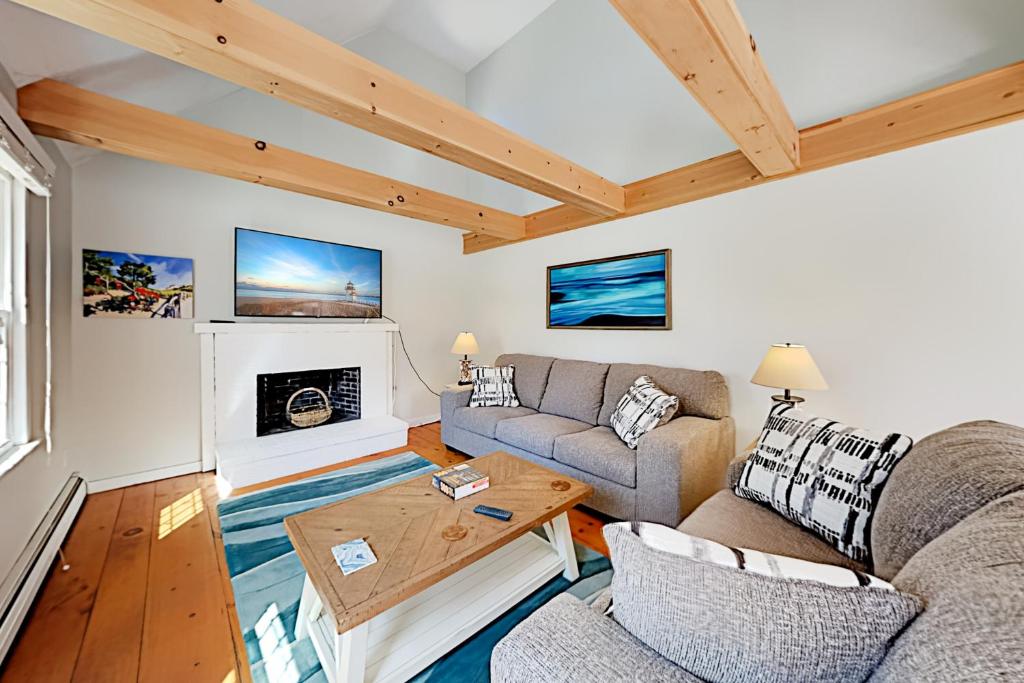 un salon avec deux canapés et une cheminée dans l'établissement Cozy Charming Cottage, à Brewster