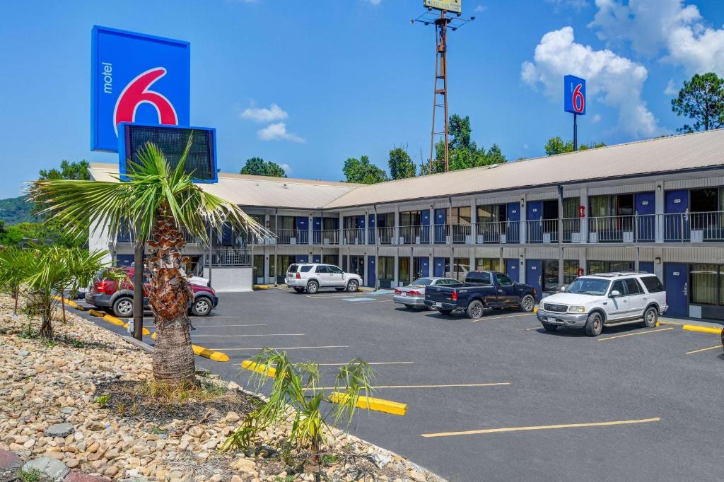 Motel 6-Dalton, GA في دالتون: فندق فيه سيارات متوقفة في مواقف