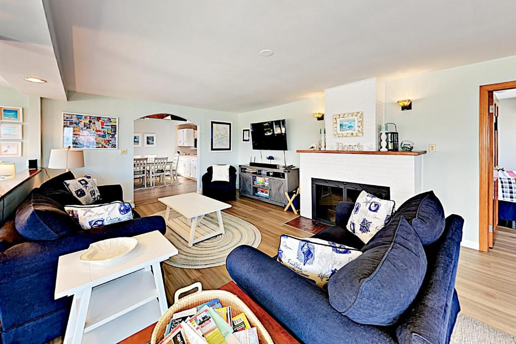 a living room with two blue couches and a fireplace at Kalmus Park Hideaway in Hyannis