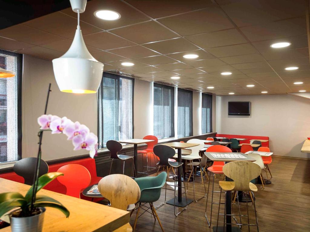 uma sala de conferências com mesas e cadeiras e um vaso de plantas em ibis Rodez Centre em Rodez