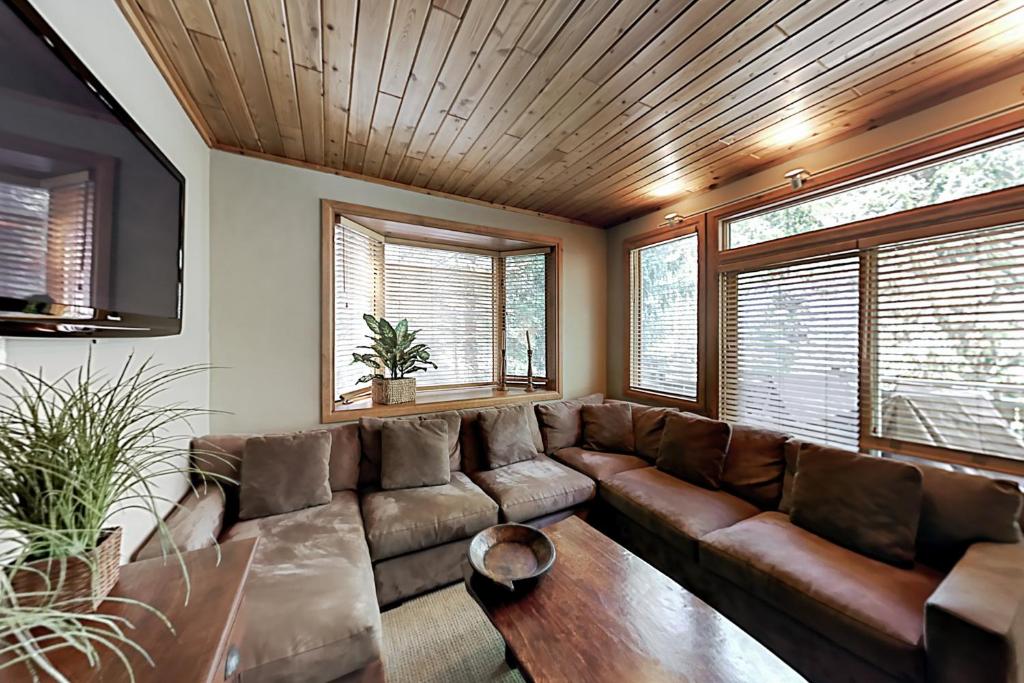 a living room with a brown couch and windows at Vail Golf Club 38 in Vail