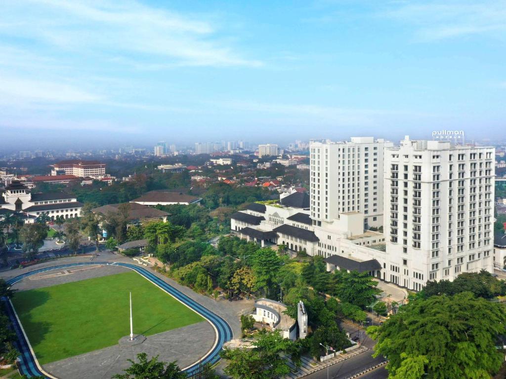 an aerial view of a city with a large white building at Pullman Bandung Grand Central in Bandung