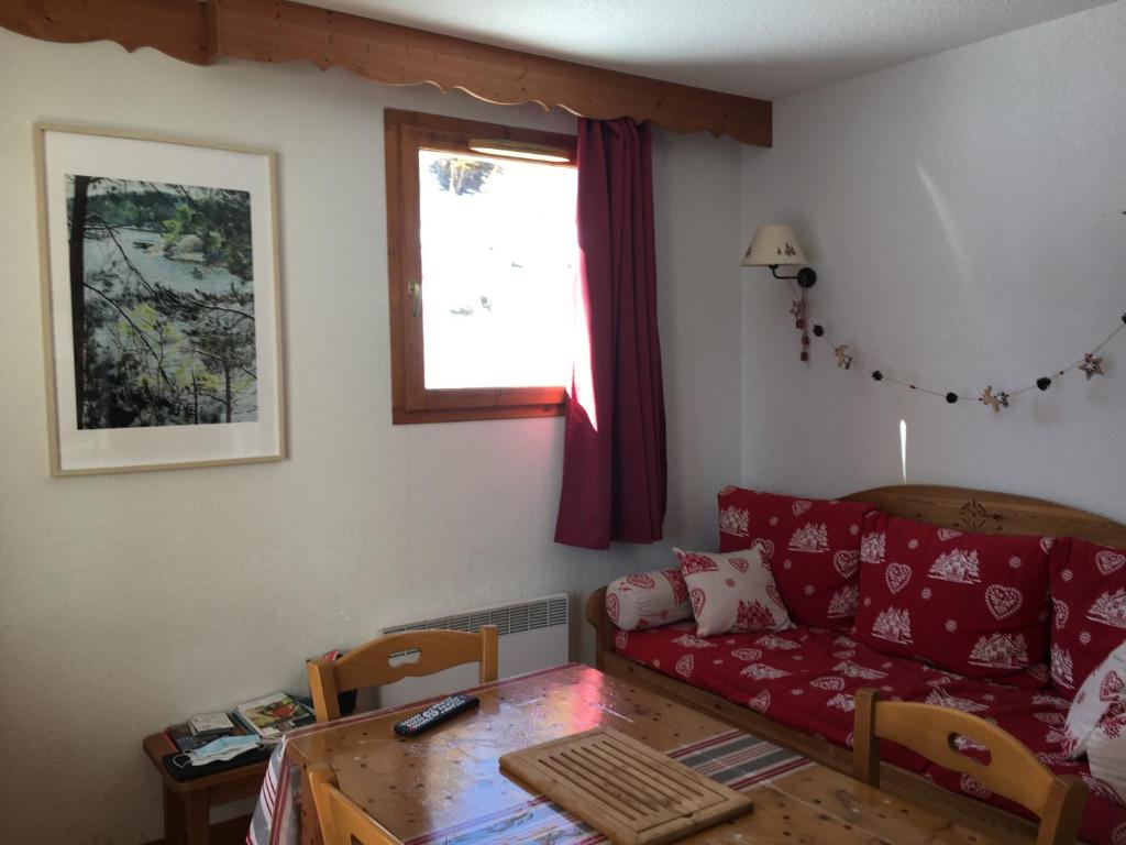 a living room with a red couch and a table at Puy St Vincent 1800 - appt 6 pers - près des pistes in Puy-Saint-Vincent