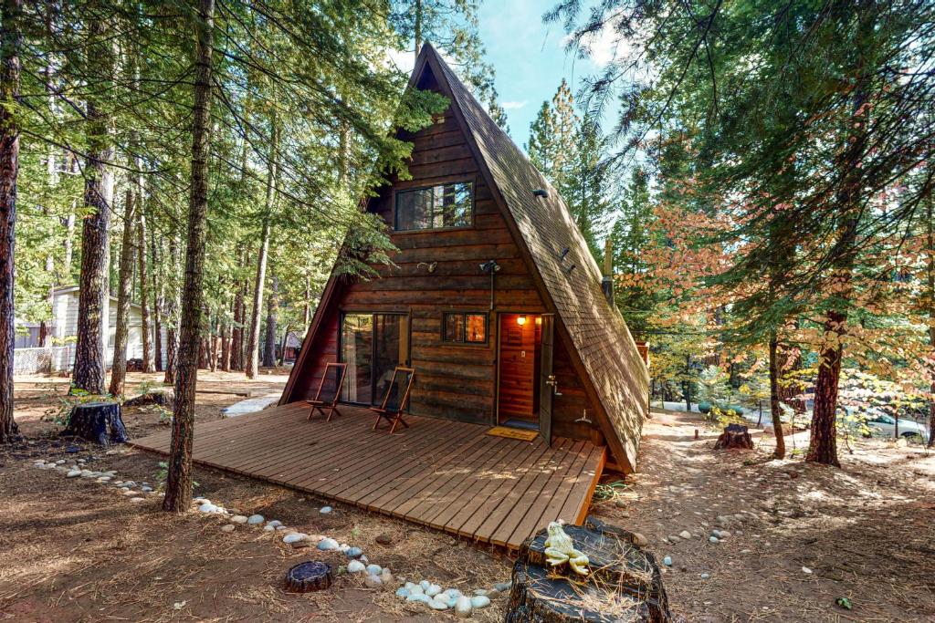 eine Hütte im Wald mit einer Holzterrasse in der Unterkunft Heavenly Daze in Arnold