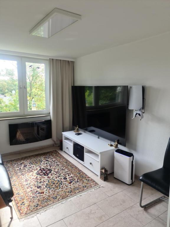 a white living room with a tv and a couch at Hannover Messe Apartment in Hannover
