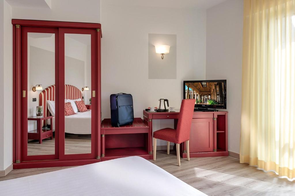 a hotel room with a bedroom with a desk and a bed at Hotel Da Vinci in Montecatini Terme