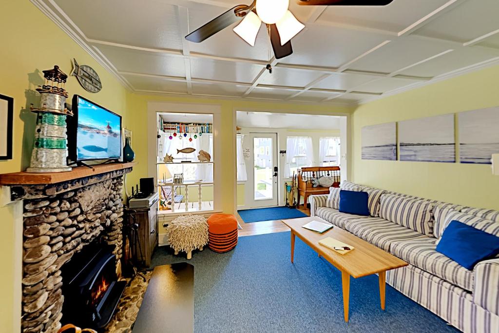 ein Wohnzimmer mit Couch und Kamin in der Unterkunft Fisher Hill Cottage in Boothbay Harbor